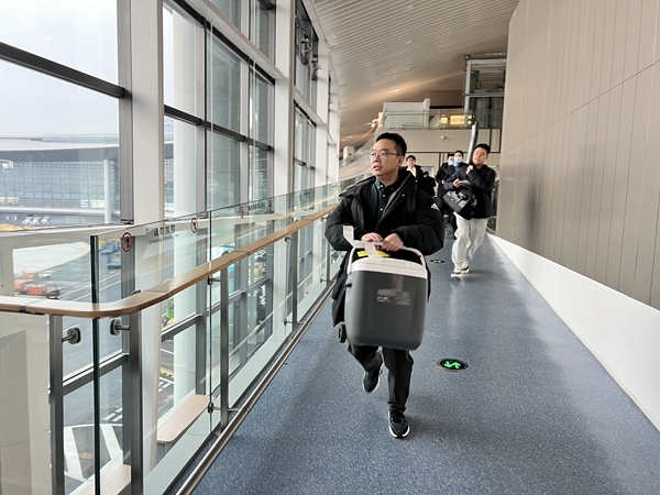 医护人员带着装有供肺的转运箱准备登机。李一芳摄