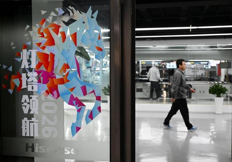 A staff member of Hisense Visual Technology walks past a production line in Qingdao, east China's Shandong Province, Jan. 13, 2026. (Xinhua/Li Ziheng)